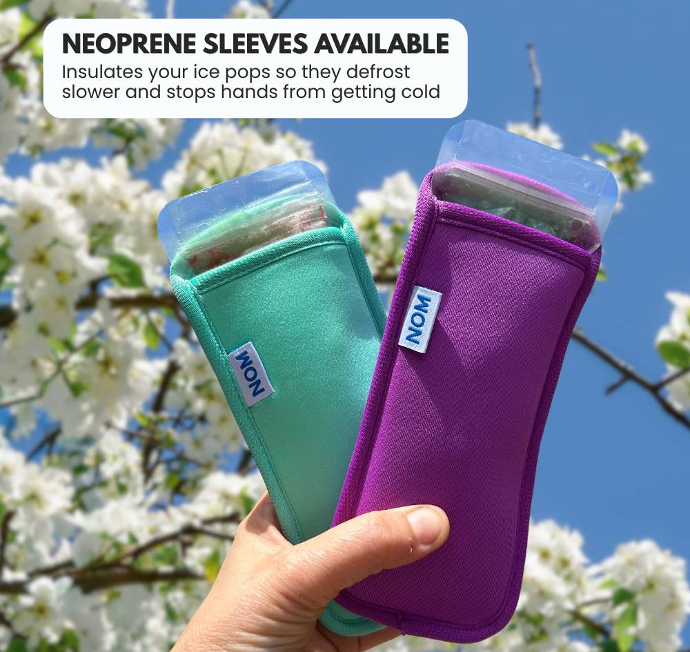 Two ice pop holders, one green and one purple, held by a hand with a cherry blossom background.