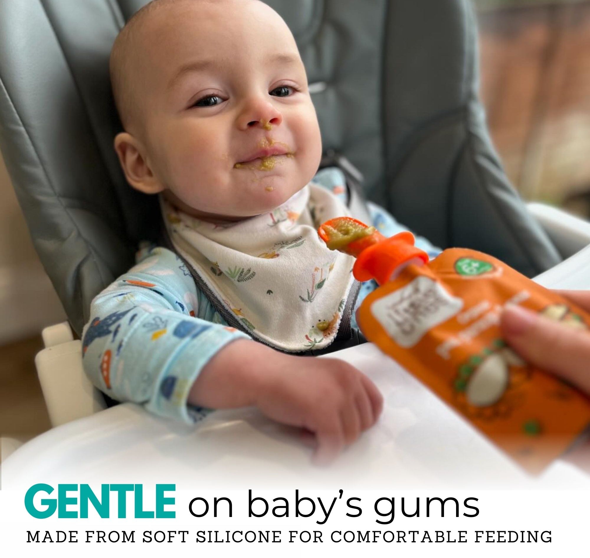 a baby sat in a high chair about to feed from a pouch of baby food using a Nom Nom Kids silicone pouch spoon