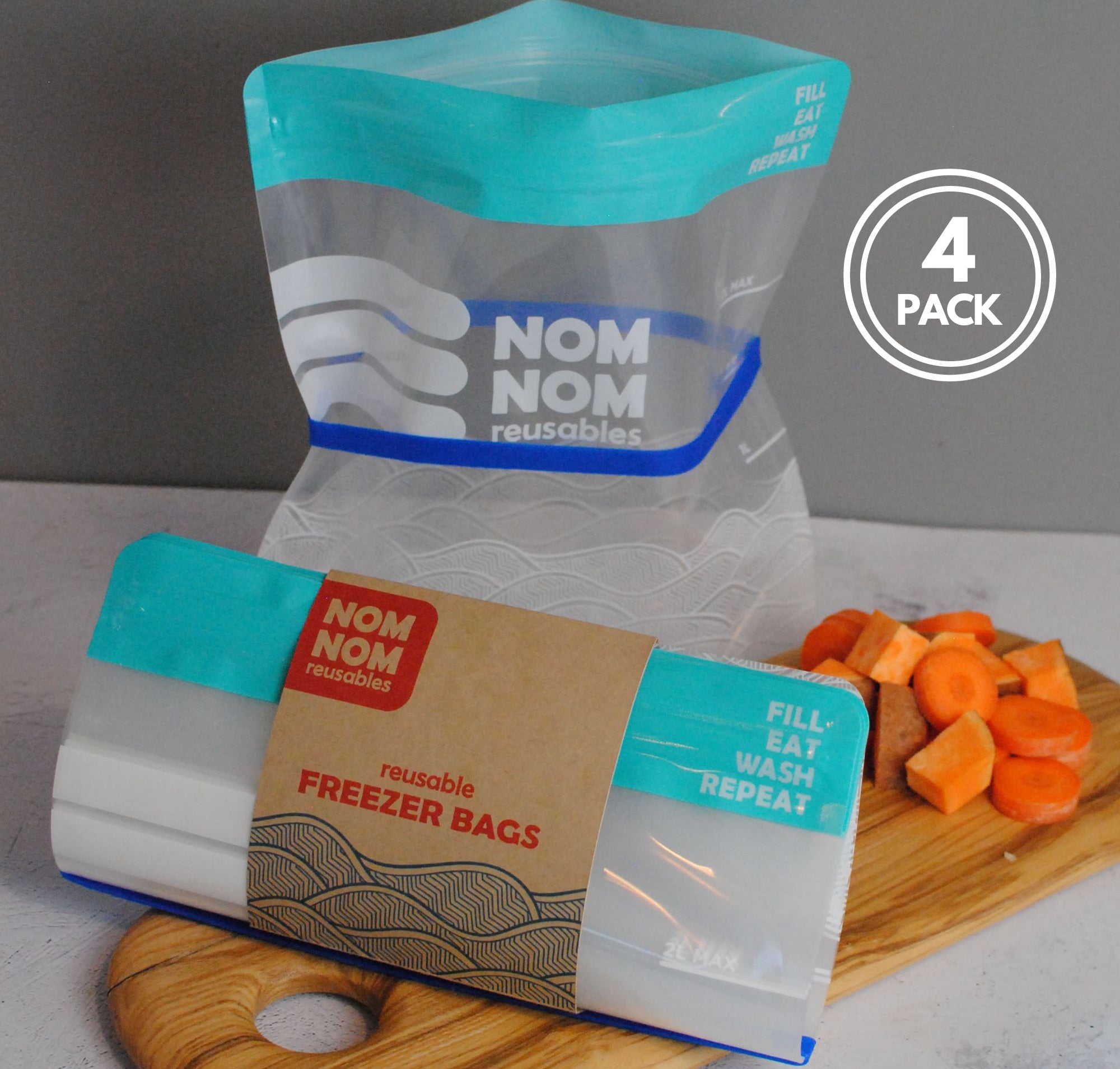 Nom Nom clear reusable freezer bags held open with a blue rubber band for easier filling