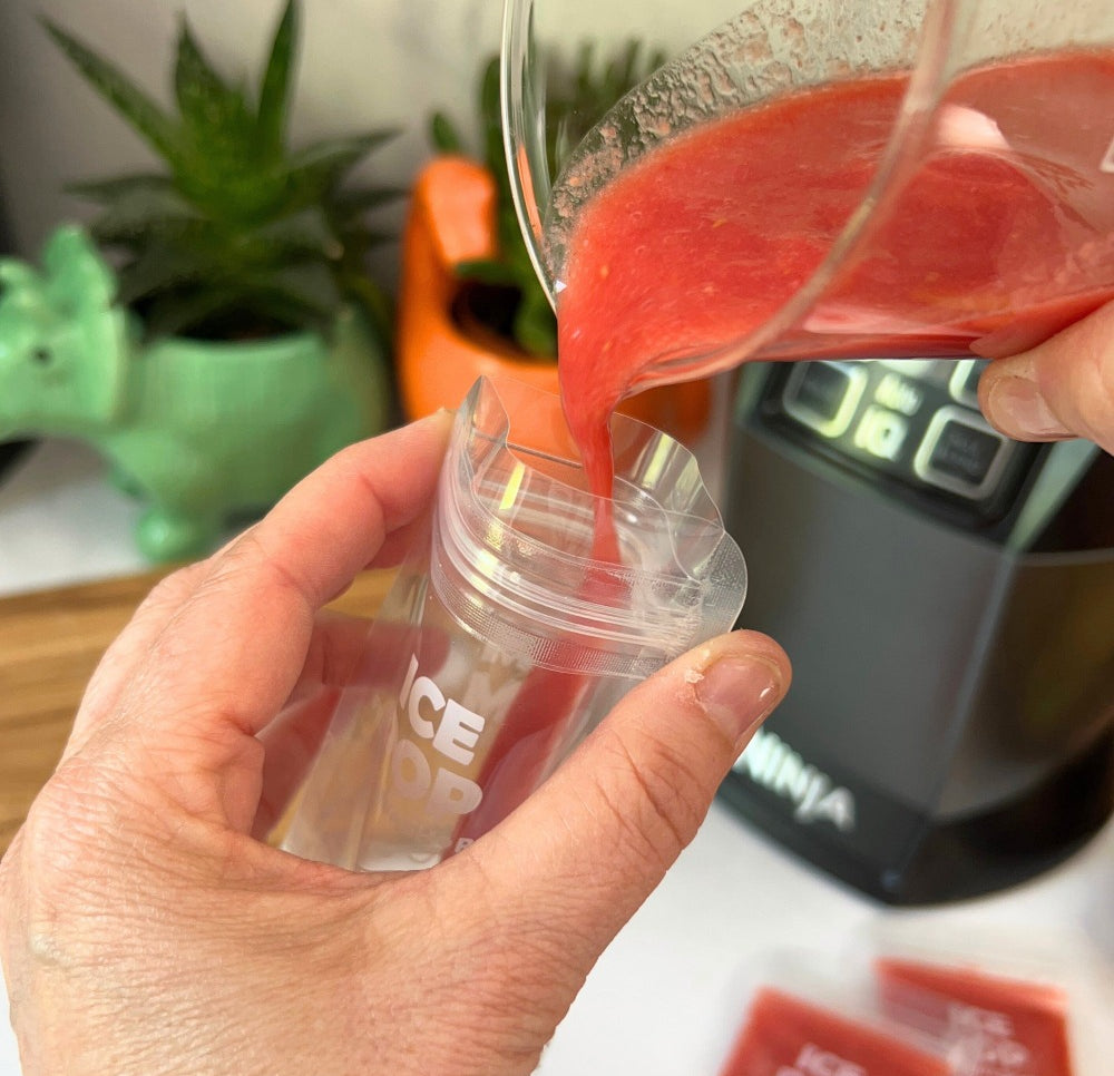 an ice pop bag being filled with a red smoothie