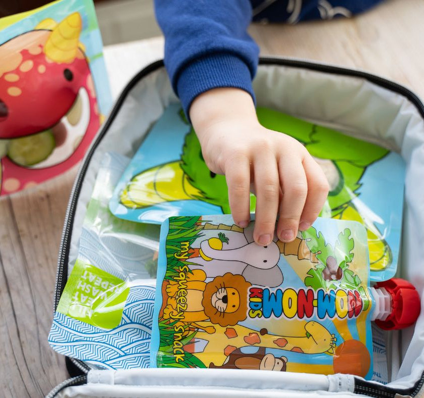 child reaching for a yogurt pouch in his packed lunch