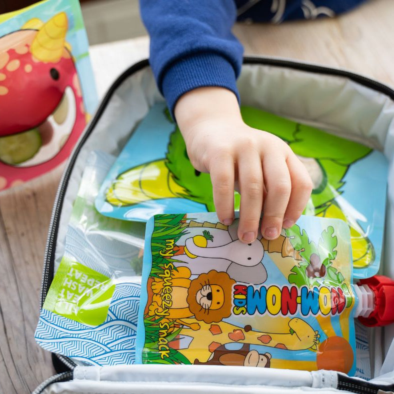 child reaching for a yogurt pouch in his packed lunch