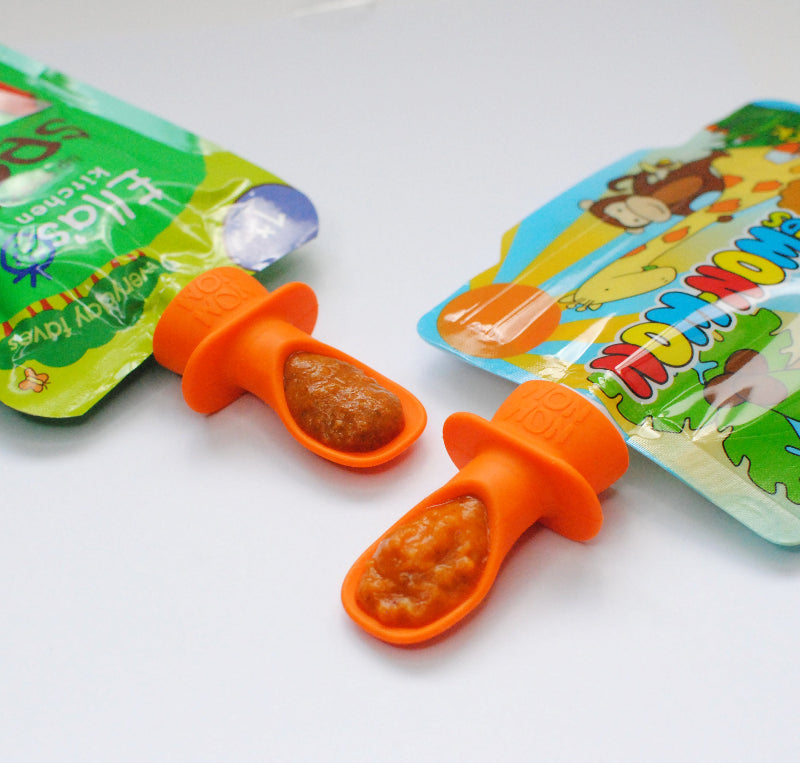 silicone pouch spoon fitted onto an Ella's Kitchen baby food pouch and a Nom Nom Kids reusable food pouch