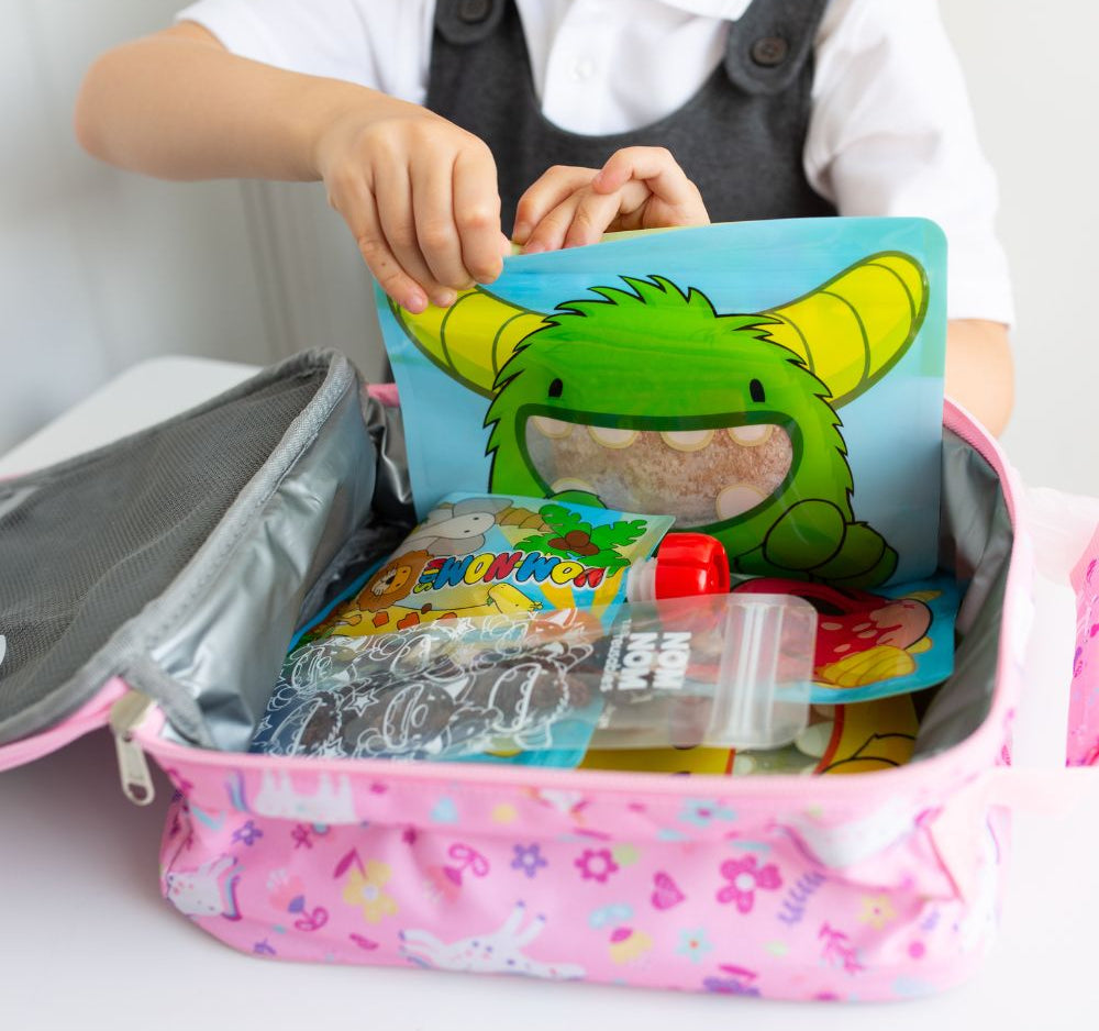 lunch box filled with Nom Nom kids reusable snack pouches. reusable yogurt pouch and ice pop bags with snacks.