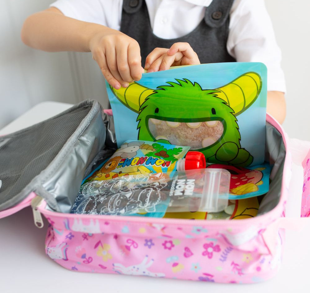 lunch box filled with Nom Nom kids reusable snack pouches. reusable yogurt pouch and ice pop bags with snacks.