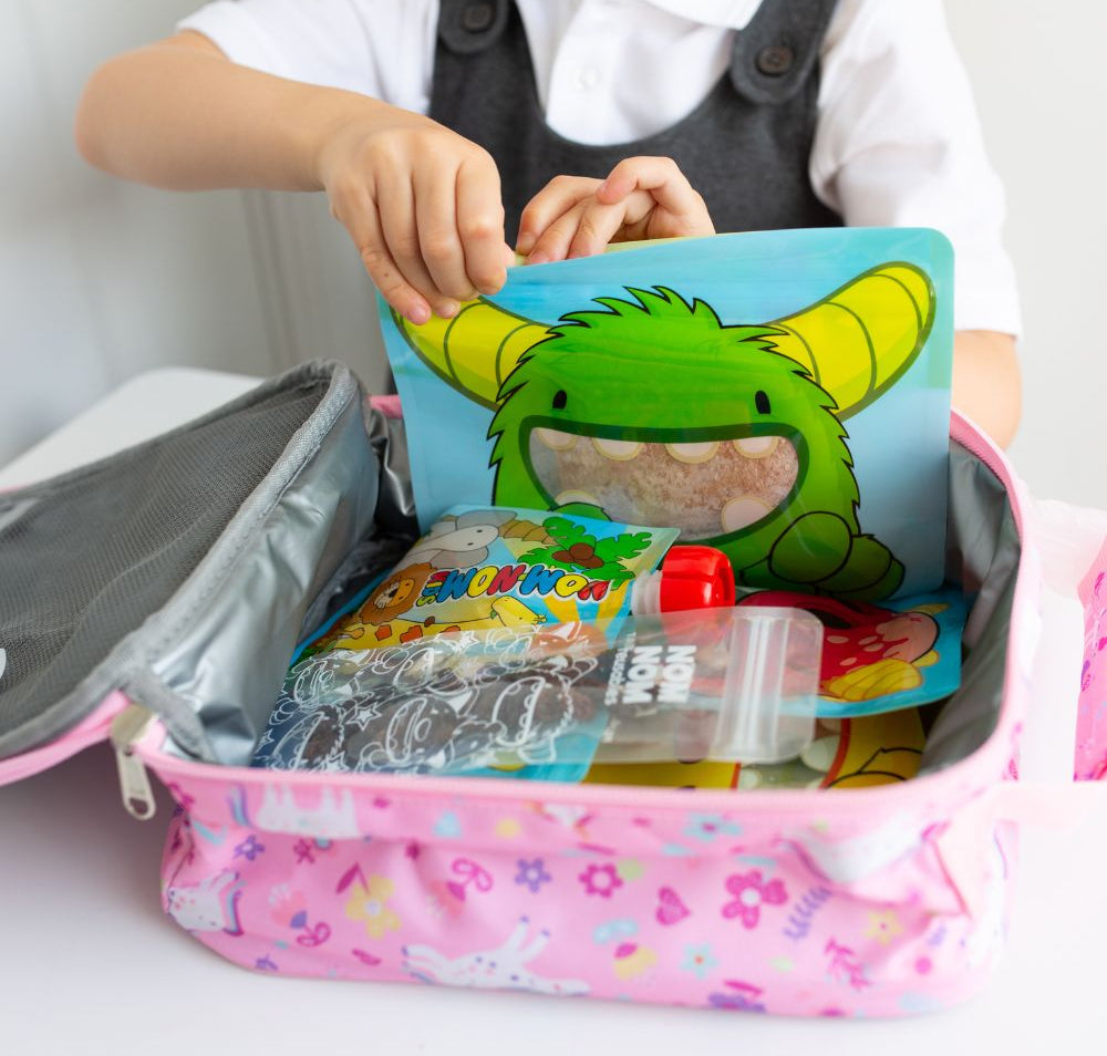 lunch box filled with Nom Nom kids reusable snack pouches. reusable yogurt pouch and ice pop bags with snacks.