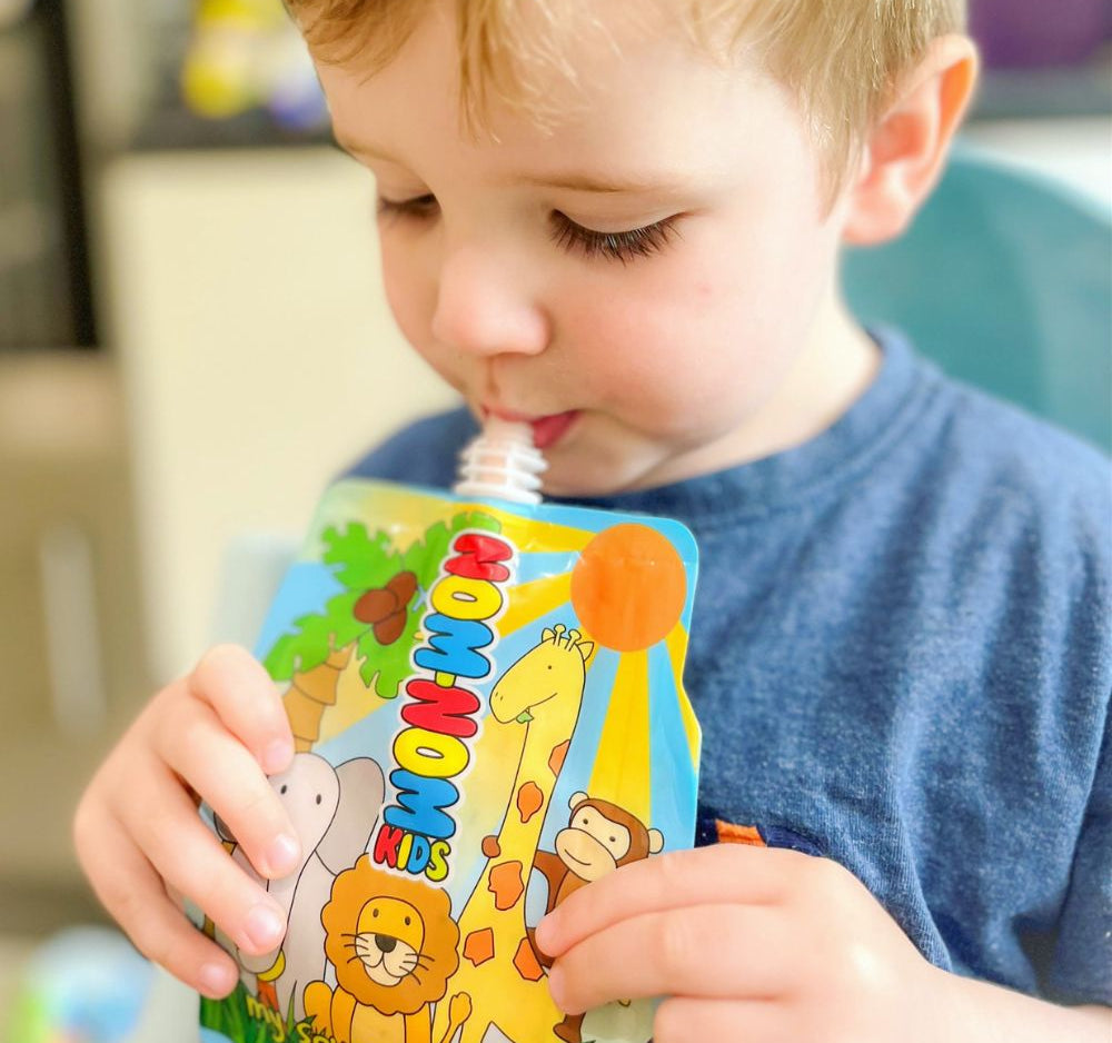 young child holding the Nom Nom kids reusable yogurt pouch.