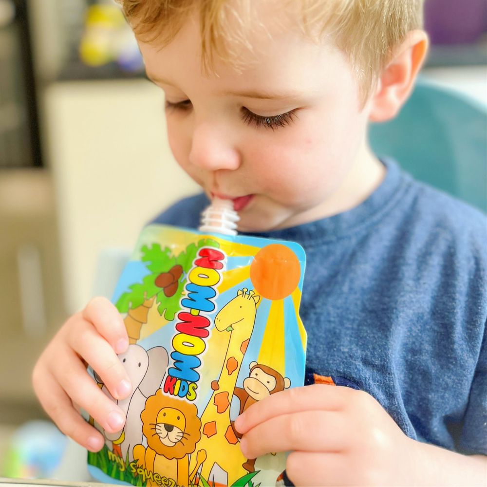 young child holding the Nom Nom kids reusable yogurt pouch.
