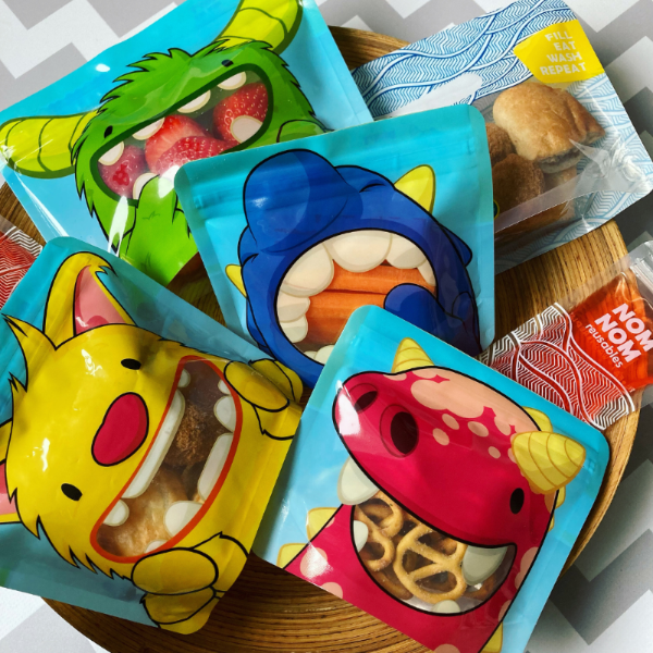 Nom Nom kids reusable snack monster bags filled with various snacks and foods