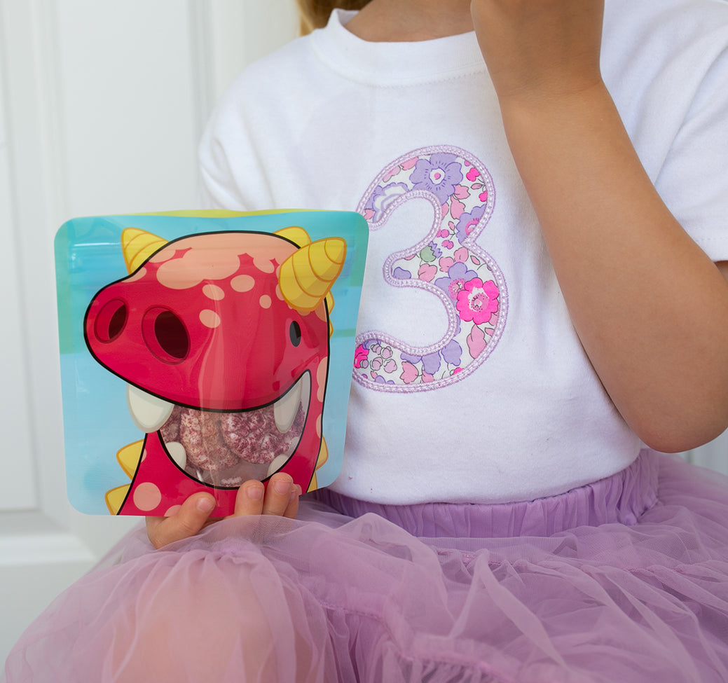 child eating flavoured rice cakes from nom nom kids reusable snack pouches.