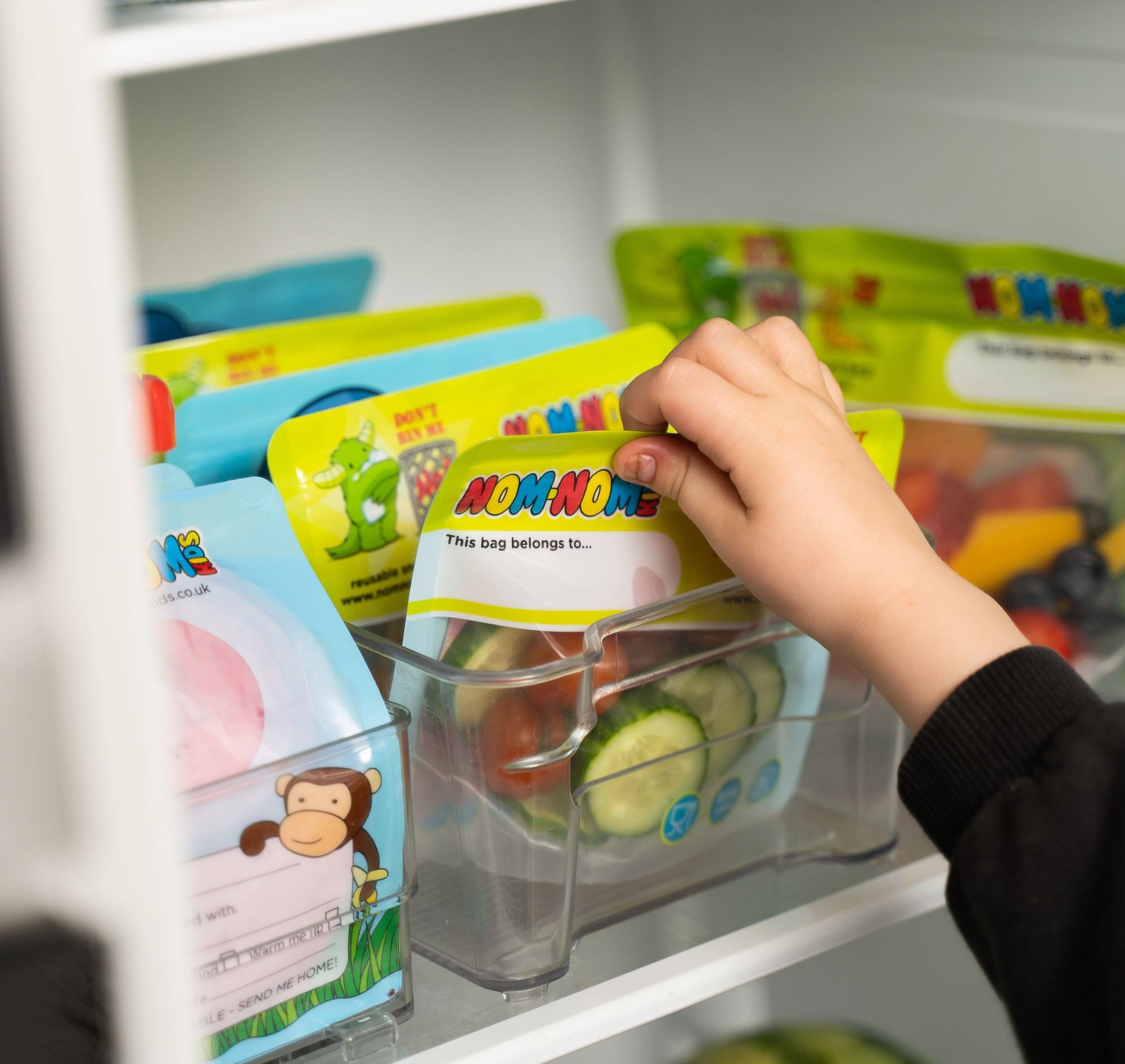 Nom Nom kids reusable snack pouches packed into an organised fridge with snack bags.