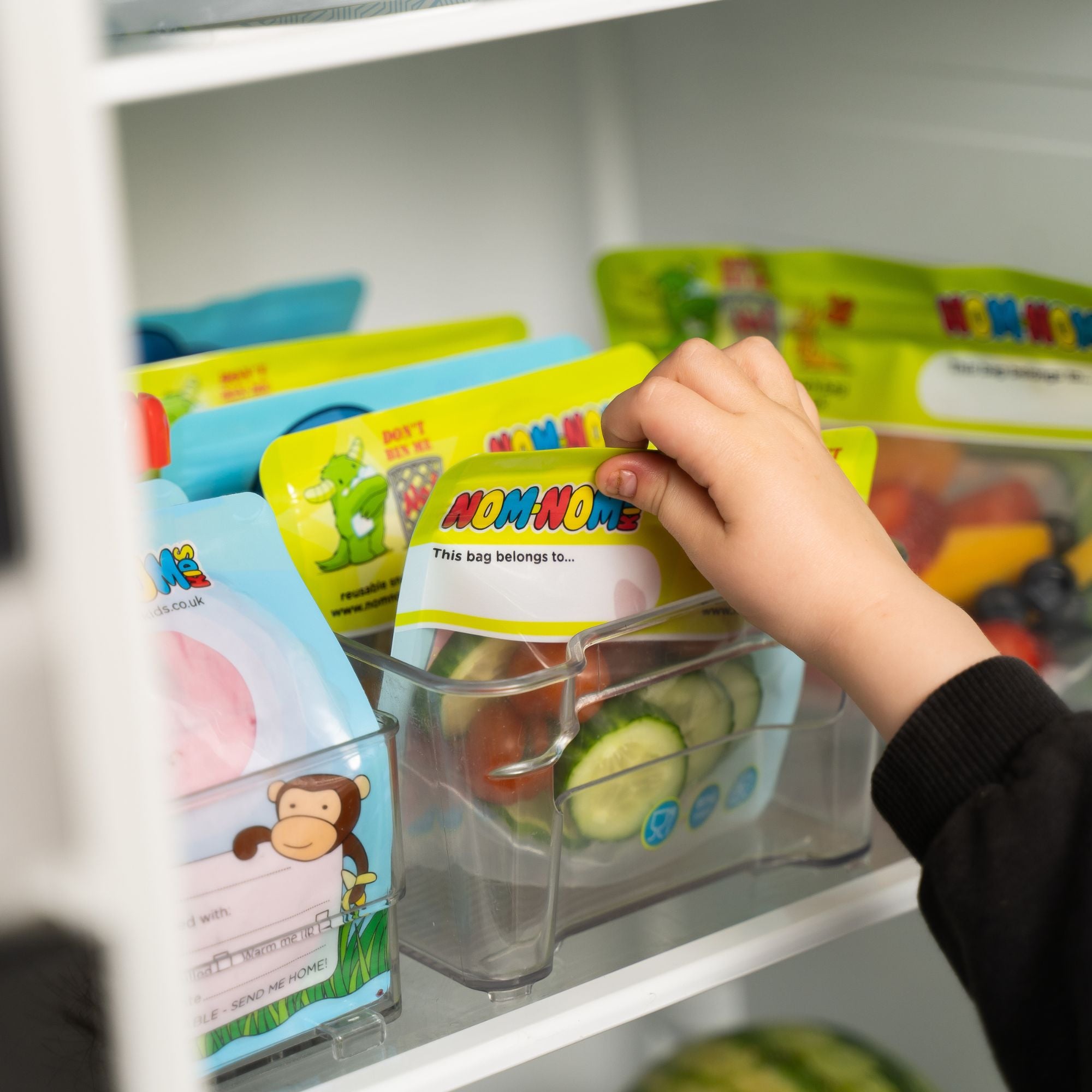 Nom Nom kids reusable snack pouches packed into an organised fridge with snack bags.