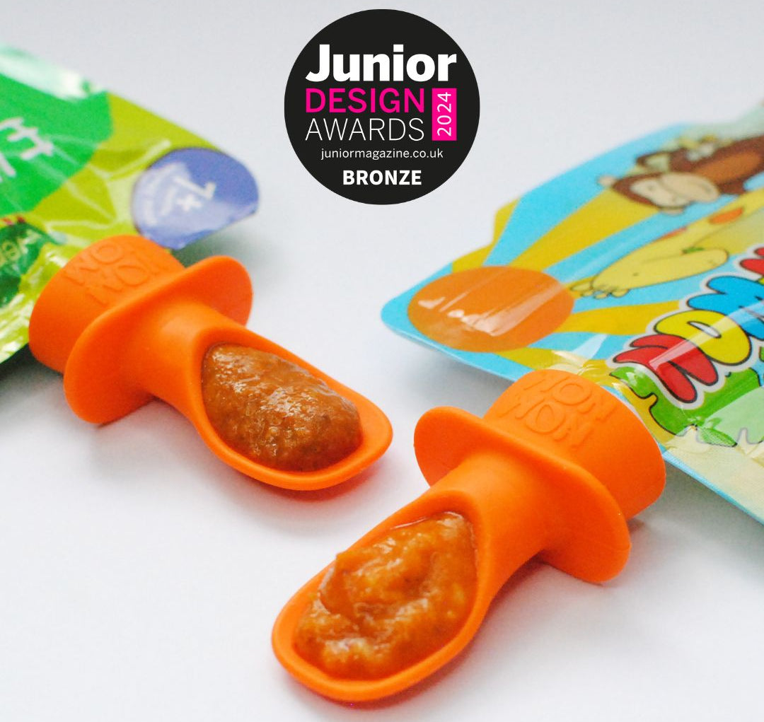 2 silicone pouch spoons. 1 attached to an Ella's Kitchen pouch and 1 attached to a Nom Nom Kids pouch with a Junior design award badge