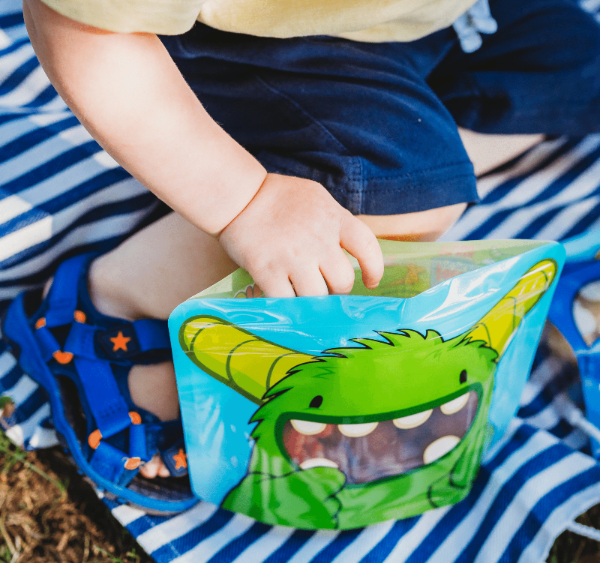 baby reaching inside Nom Nom kids reusable sandwich bag