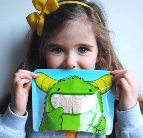 little girl holding Nom Nom kids sandwich bag