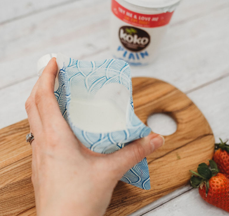 Nom Nom kids reusable yogurt pouch being filled with yogurt