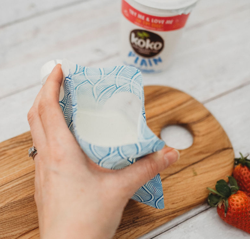 Nom Nom kids reusable yogurt pouch being filled with yogurt