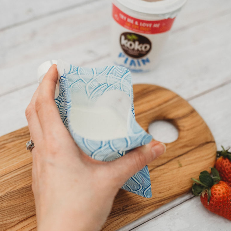 Nom Nom kids reusable yogurt pouch being filled with yogurt