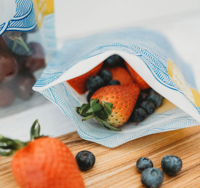 Nom Nom kids reusable snack bag filled with strawberries and bluberries.