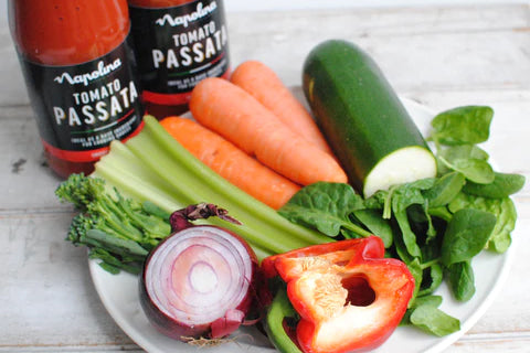 plate of vegetables in front of tomato passata jars 