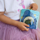 child eating cucumber stick snacks from a Nom Nom kids reusable snack bag