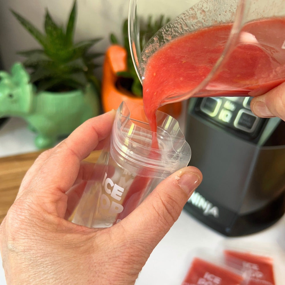 an ice pop bag being filled with a red smoothie