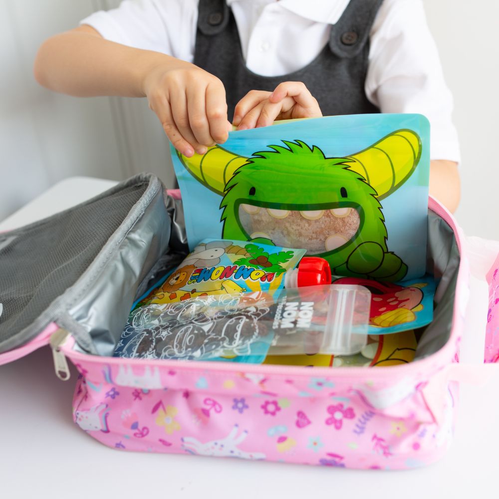 lunch box filled with Nom Nom kids reusable snack pouches. reusable yogurt pouch and ice pop bags with snacks. 